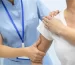 Woman doctor osteopath in medical uniform fixing woman patients shoulder and back joints in manual therapy